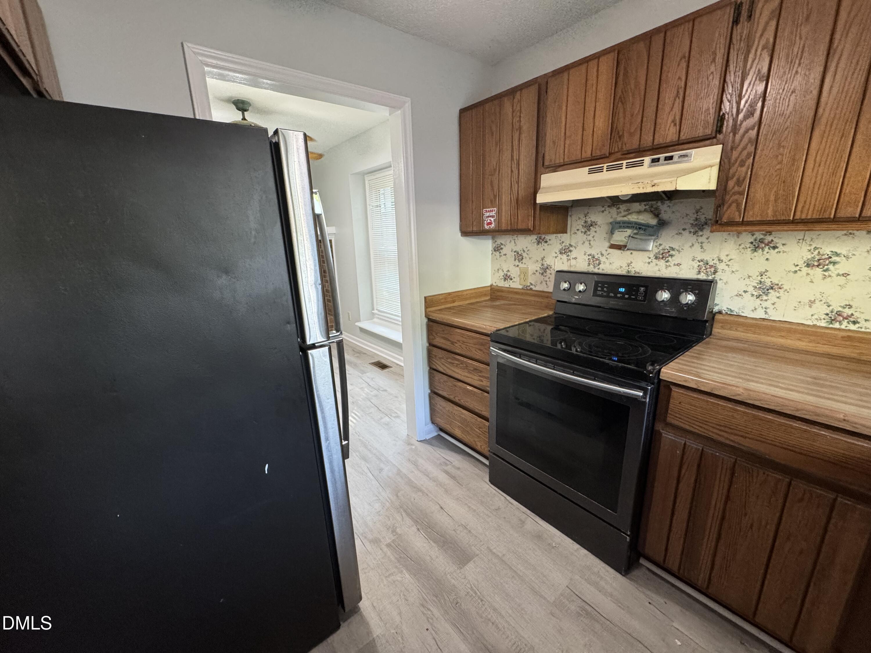 4200 Bertram Drive Raleigh, NC 27604 - Photo 4 of 16 a kitchen with stainless steel appliances granite countertop a stove a refrigerator and a cabinets
