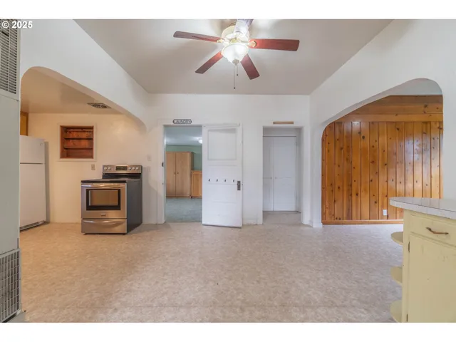 a view of an empty room with a fireplace and a chandelier