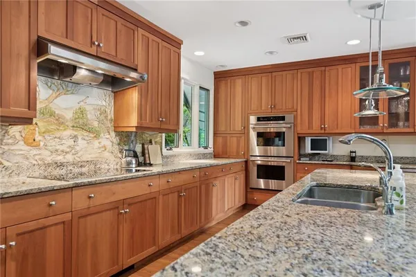 a kitchen with stainless steel appliances granite countertop a sink stove and cabinets