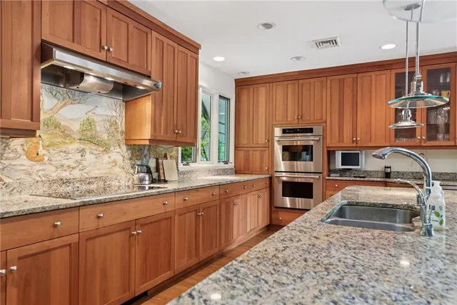 a kitchen with stainless steel appliances granite countertop a sink stove and cabinets