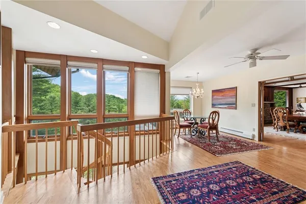 a living room with furniture floor to ceiling window and wooden floor