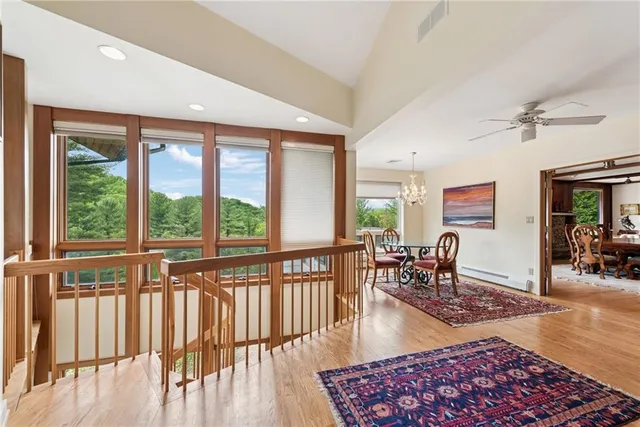 a living room with furniture floor to ceiling window and wooden floor