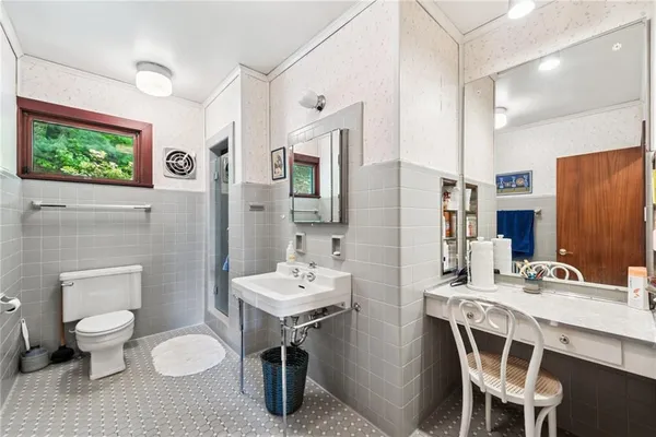 a bathroom with a sink a toilet and a mirror