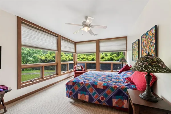 a bedroom with a bed and a large window with the outer view