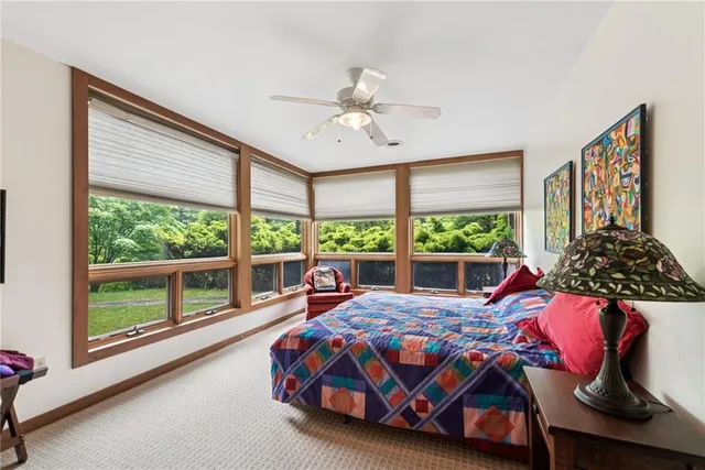 a bedroom with a bed and a large window with the outer view