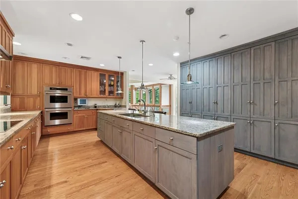 a kitchen with stainless steel appliances granite countertop a sink refrigerator and cabinets