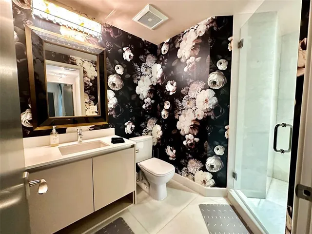 a bathroom with a sink mirror vanity and toilet