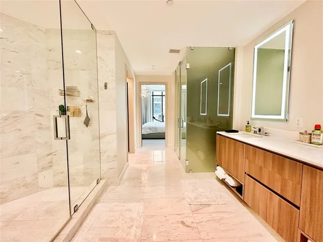 a bathroom with a glass shower door and a sink