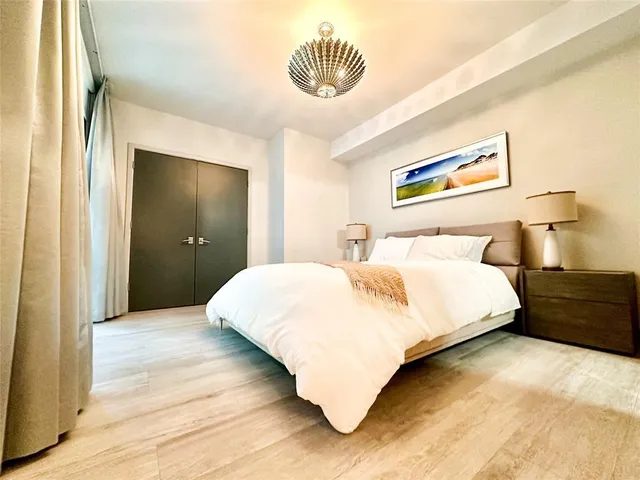 a bedroom with a bed and a painting on the wall