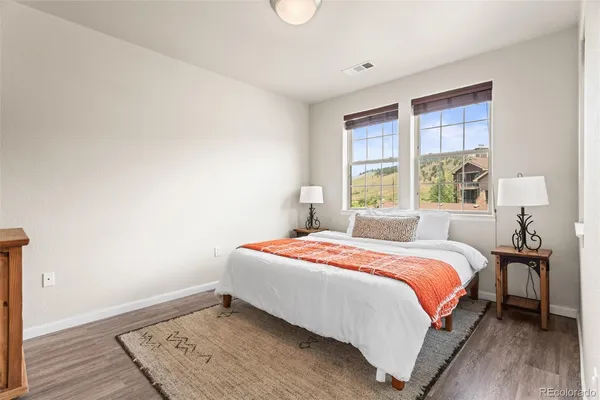 a bedroom with a bed and wooden floor
