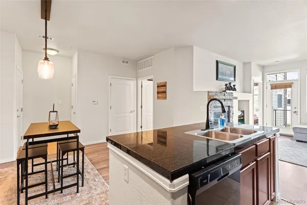 a kitchen with stainless steel appliances granite countertop a stove white cabinets a sink and a refrigerator