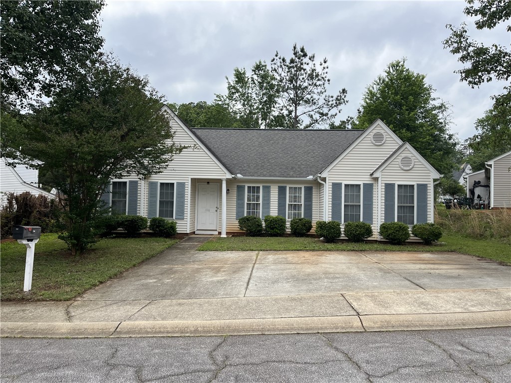 A classic facade with contrasting blue shutters and a neatly maintained lawn welcomes you home.