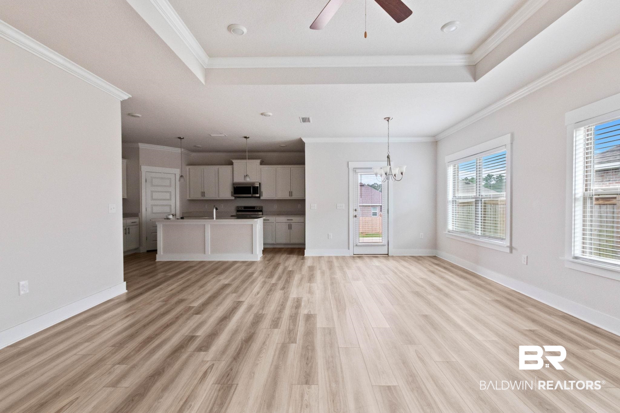1710 Grouse Street Foley, AL 36535 - Photo 16 of 76 Open-concept living area featuring wood-finish flooring, a tray ceiling with recessed lighting and a ceiling fan, and white baseboards