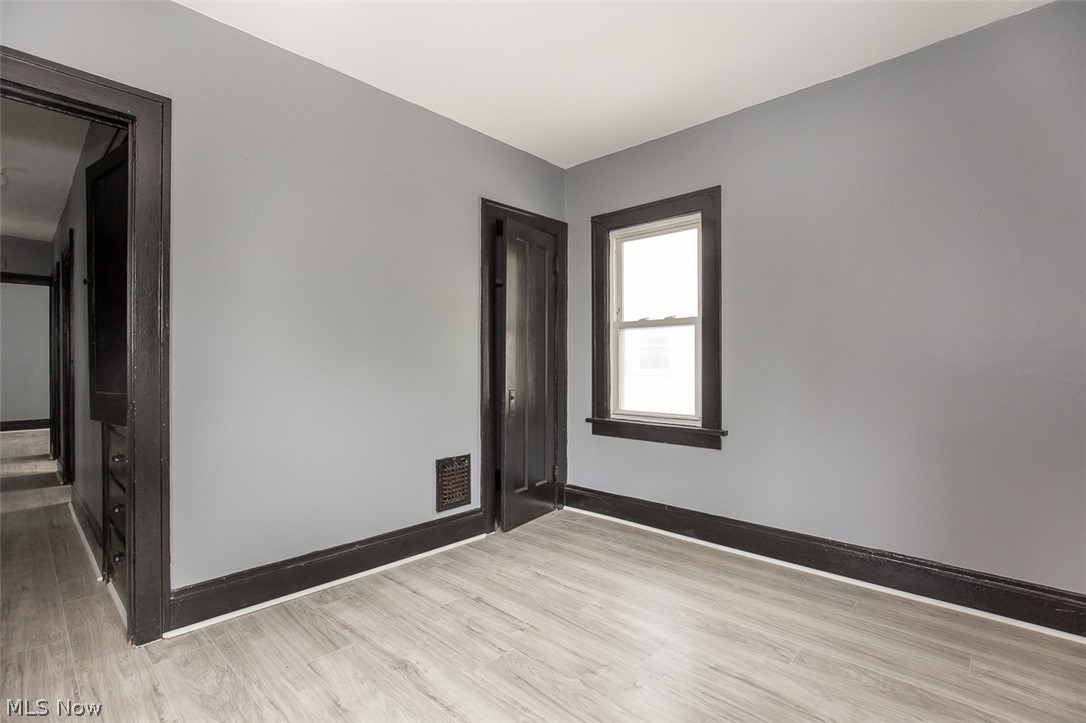 1868-1870 Lampson Road Cleveland, OH 44112 - Photo 35 of 36 Room featuring light gray walls, dark trim, and wood-finish flooring