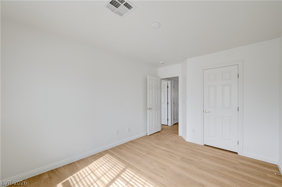 8918 Houston Ridge Avenue Las Vegas, NV 89178 - Photo 8 of 35 Blonde wood flooring and brilliant sunlight create a cheerful and open room.