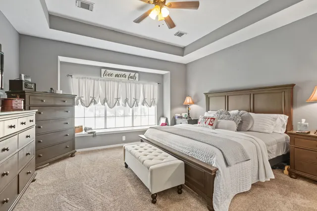 a bedroom with a bed and a chandelier fan