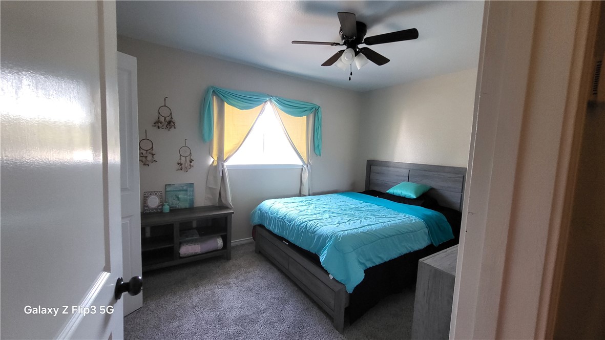 5018 Queen's Court Corpus Christi, TX 78413 - Photo 24 of 26 a bedroom with a bed and a chandelier