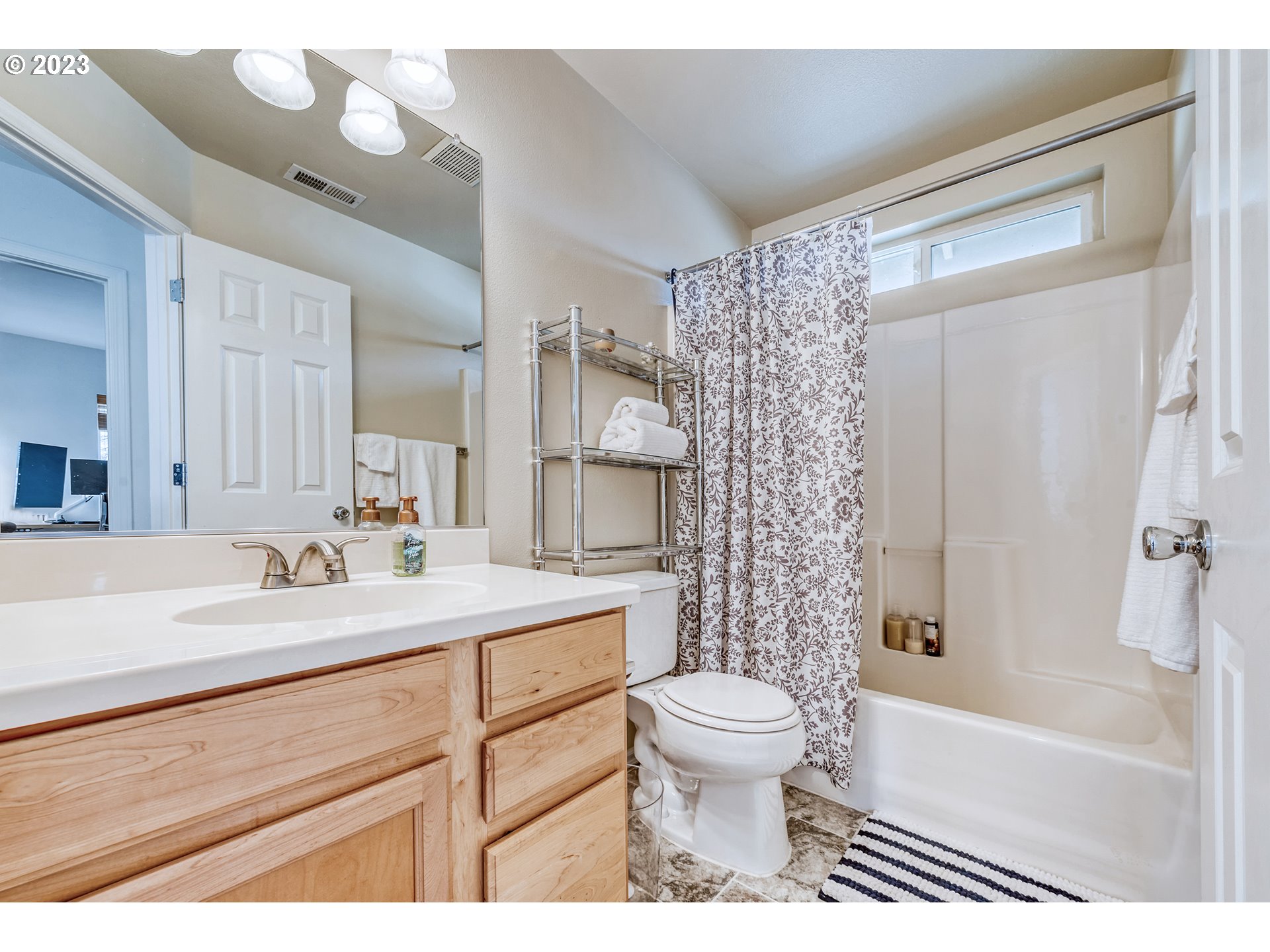 5588 Wales Drive Eugene, OR 97402 - Photo 31 of 41 a bathroom with a sink a toilet a mirror a bathtub and shower
