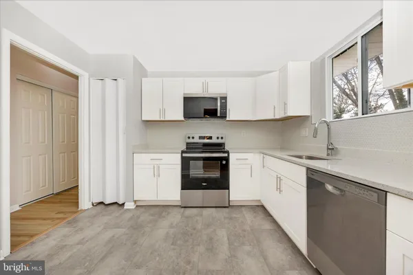 a kitchen with granite countertop white cabinets and white appliances