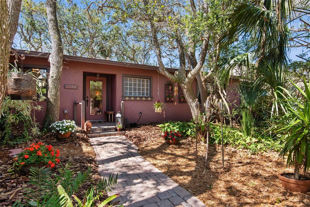 2250 South Daytona Avenue Flagler Beach, FL 32136 - Photo 1 of 1 a view of a house with lots of flower plants and large trees