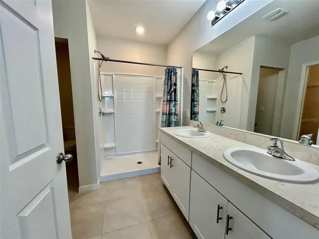 a bathroom with a granite countertop toilet and a shower