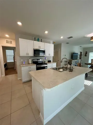a kitchen with stainless steel appliances a refrigerator sink stove and microwave