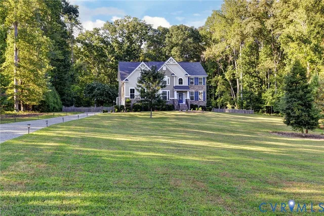a view of a big house with a big yard and large trees