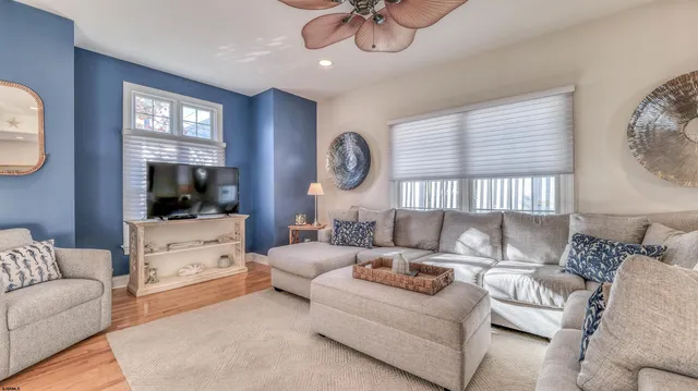 a living room with furniture a flat screen tv and a window