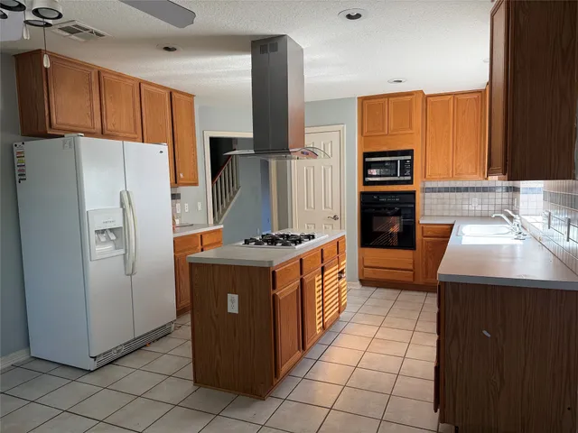 a kitchen with a stove top oven sink and cabinets