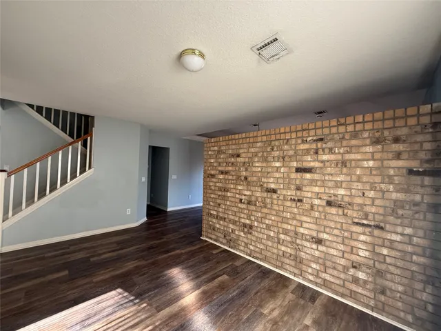 a view of empty room with wooden floor and fireplace