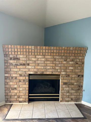 a view of an empty room with wooden floor and a ceiling fan