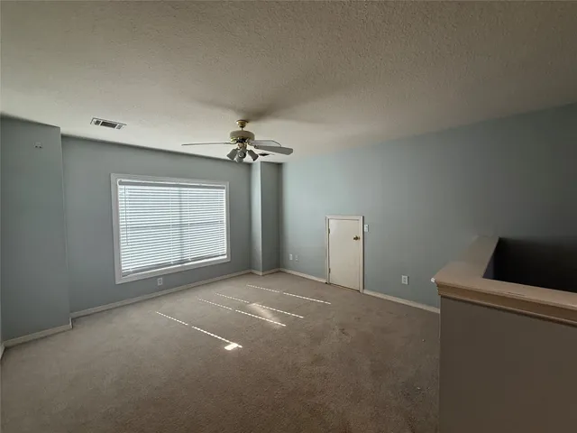 a view of a livingroom with a ceiling fan and window