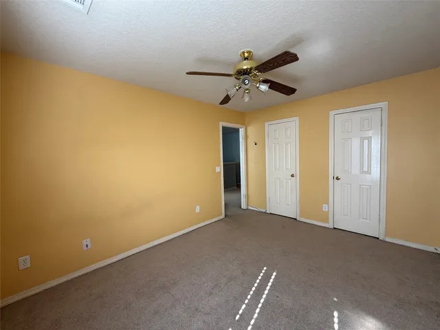 a view of an empty room with a ceiling fan