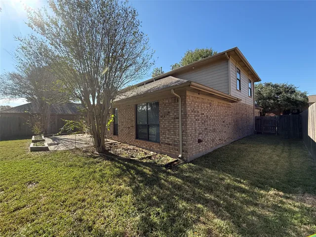 a view of a house with backyard and a tree