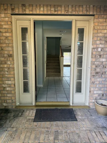 a view of a hallway with wooden floor and a bathroom