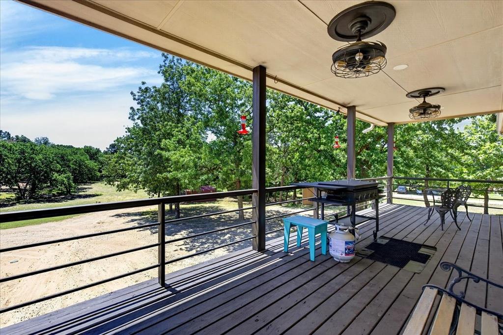 11591 Farm To Market 59 Athens, TX 75751 - Photo 29 of 40 Spacious outdoor deck featuring wood-finish flooring and a black metal railing overlooking a tree-lined landscape