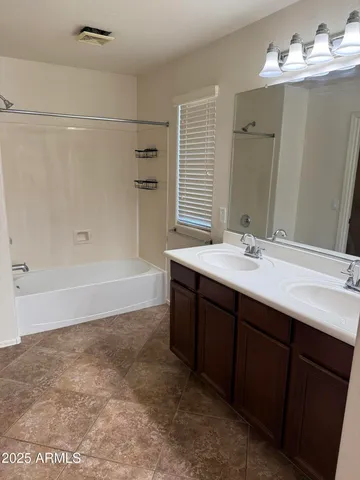 a bathroom with a double vanity sink mirror and shower