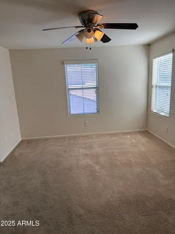 an empty room with a window and a ceiling fan