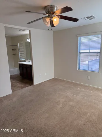 a view of a livingroom with a ceiling fan and window