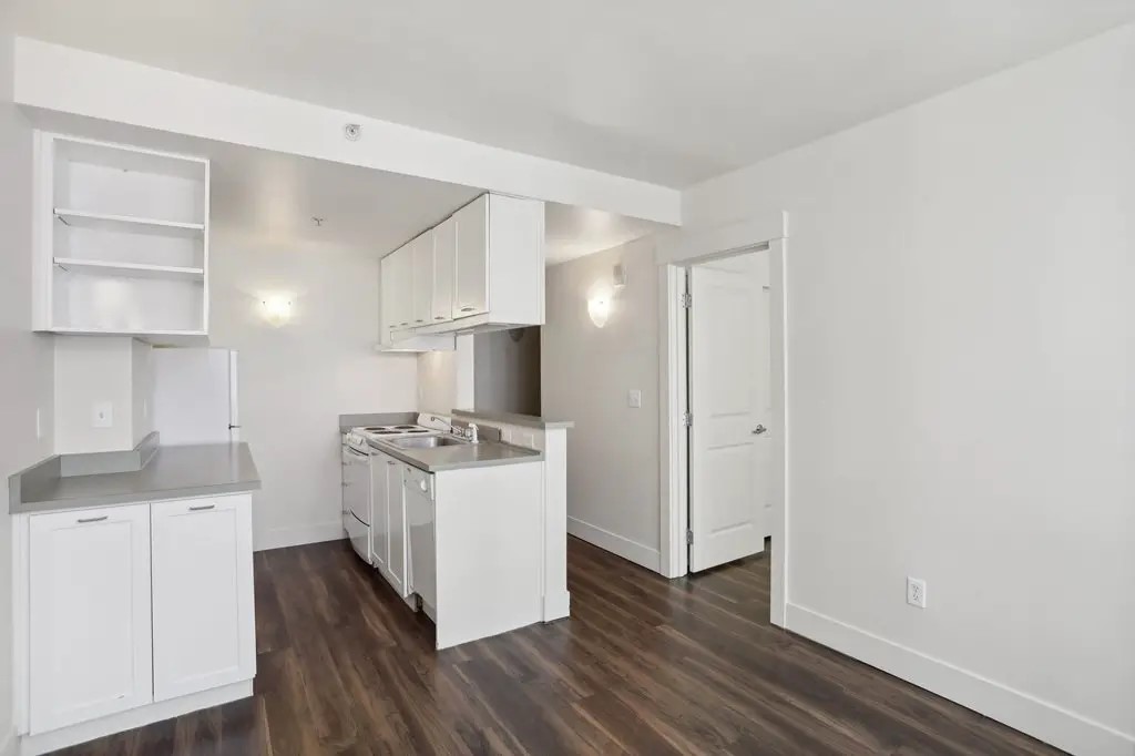 201 Yesler Way Seattle, WA 98104 - Photo 11 of 21 a kitchen with cabinets and wooden floor