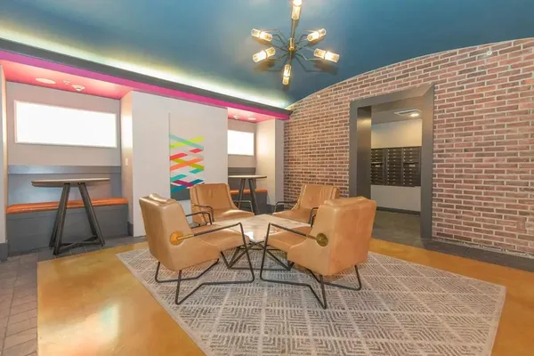 a living room with furniture a rug and a floor to ceiling window