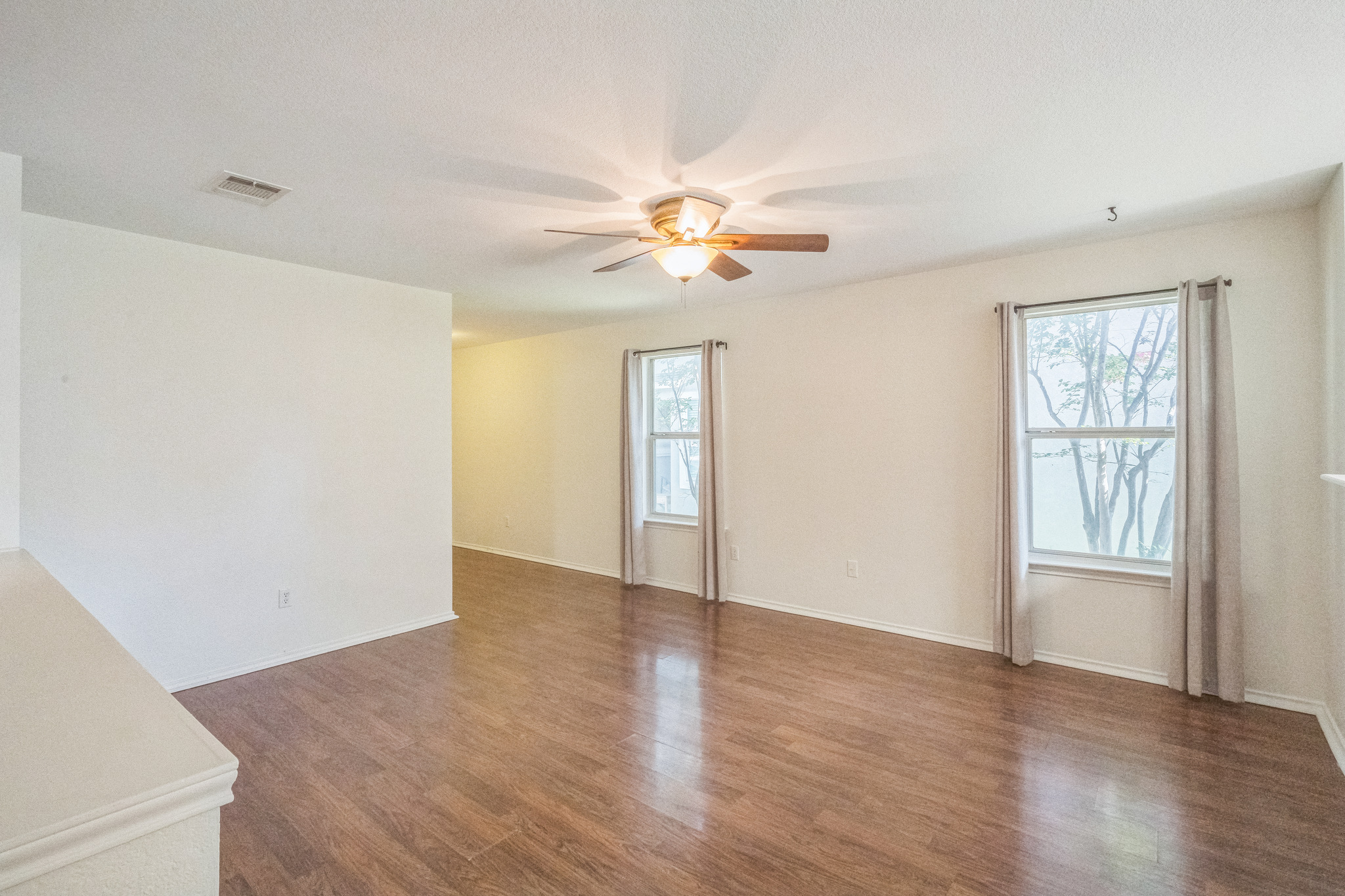 77 Jan Lane Georgetown, TX 78626 - Photo 13 of 16 Natural light illuminates rich hardwood flooring in this spacious, open-concept interior.