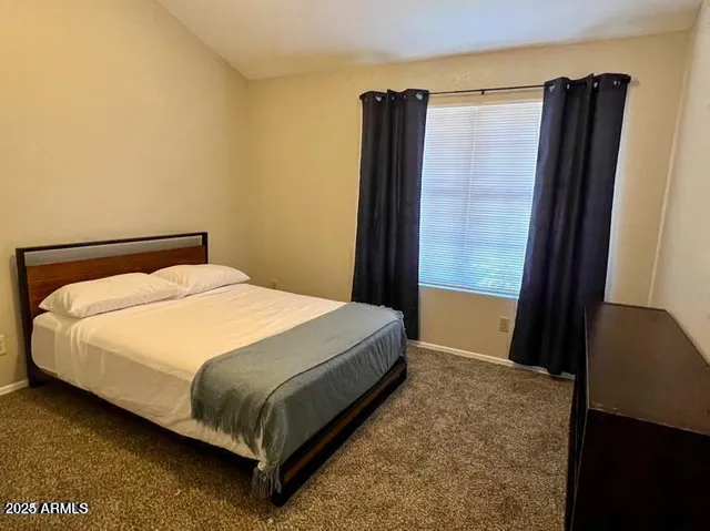 a bed sitting in a bedroom next to a window