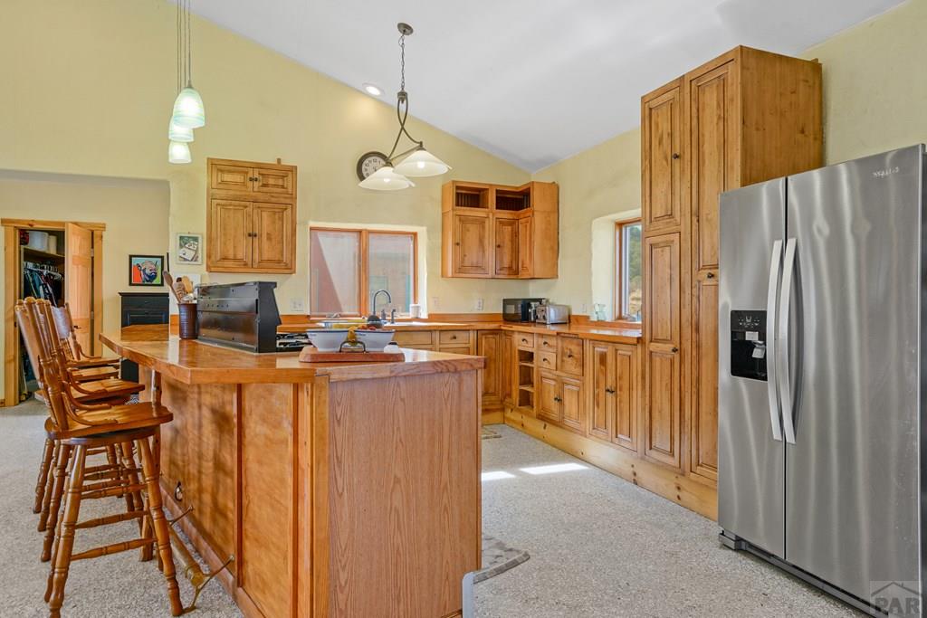 13045 Picketwire Road Boncarbo, CO 81024 - Photo 6 of 42 a kitchen with stainless steel appliances kitchen island granite countertop a refrigerator a stove a sink dishwasher and white cabinets with wooden floor