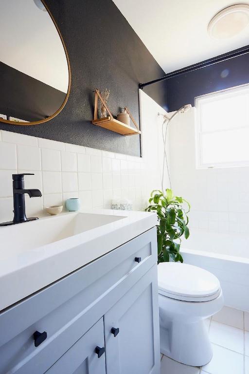 4704 Bandera Road Austin, TX 78721 - Photo 11 of 18 a bathroom with a sink a mirror and a toilet