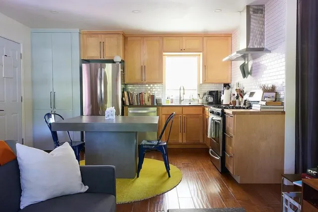 a dining room with furniture a large window and wooden floor