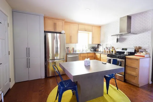 a kitchen with a table chairs refrigerator and cabinets