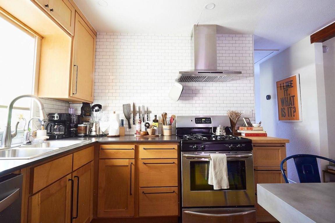 4704 Bandera Road Austin, TX 78721 - Photo 7 of 18 a kitchen with stainless steel appliances a stove a sink dishwasher and wooden cabinets