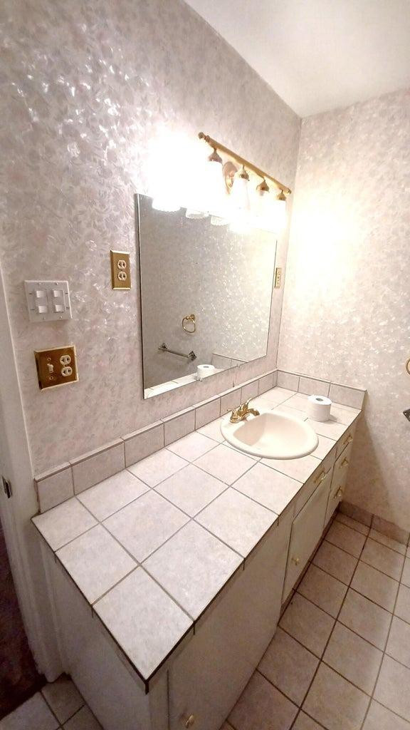 206 South W 7th Street Lockney, TX 79241 - Photo 23 of 47 a bathroom with a sink a mirror and a shower