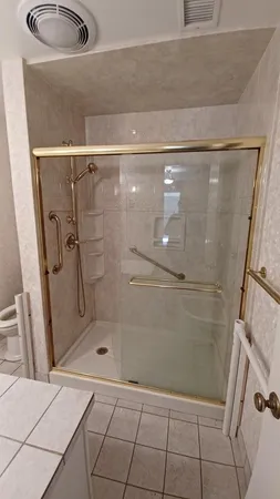 a bathroom with a granite countertop sink a toilet and shower